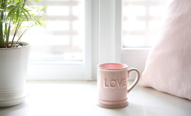 Fresh morning tea.Mug on window sill.Love word, valentine's design background.Good mood concept.