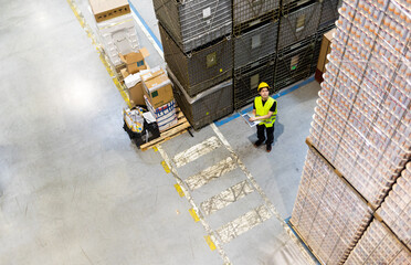 Checking warehouse database of inventory with laptop, view from above