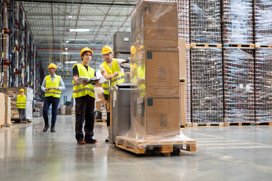 Employees Consult While Working In The Warehouse