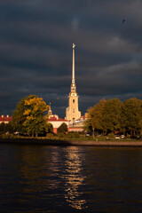 Fototapeta na wymiar Autumn stormy sunset with dark clouds in front of Peter and Paul fortress in Saint-Petersburg, Russia, birds