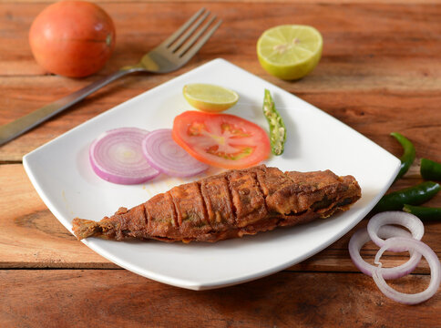 The Indian mackerel (Rastrelliger kanagurta) , Malwani Bangda fry, Fish fry.. on a rustic wooden background, selective focus