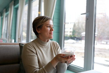 Woman holding candle next to window