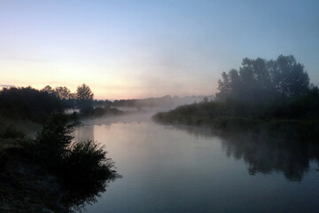 Fototapeta na wymiar Beautiful misty morning over a winding river.