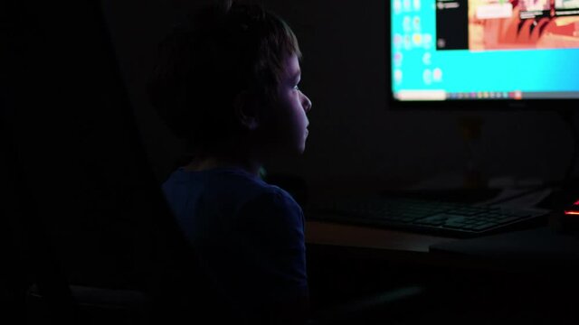 Asian boy late at night launches the game on the computer, typing something interesting surfing Internet, moonlight shines from window. close up view. Slow motion nvideo. stock footage