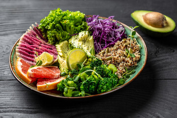 Trendy salad with quinoa, micro greens, avocado, grapefruit, broccoli, watermelon radish, red cabbage. Restaurant menu, dieting, cookbook recipe. Top view, flat lay, copy space