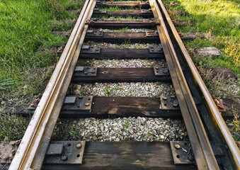 Fototapeta na wymiar Old, dirty, oiled rails and wooden sleepers on the railroad. Photo, top view.
