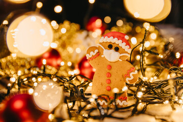 Gingerbread masked man cookies on the background with unfocused lights: New Year and Christmas celebration in a coronavirus pandemic