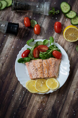 Salmon in a pan with lemon and other vegetables. Salmon on plates