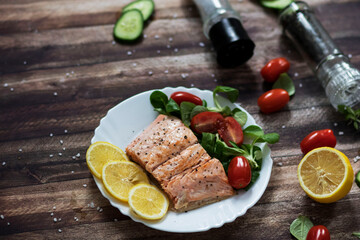 Salmon in a pan with lemon and other vegetables. Salmon on plates