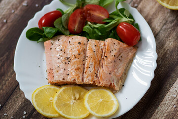 Salmon in a pan with lemon and other vegetables. Salmon on plates
