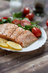 Salmon in a pan with lemon and other vegetables. Salmon on plates