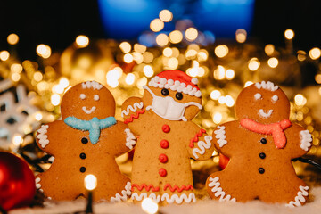 New Year and Christmas celebration in a coronavirus pandemic, conceptual background with unfocused lights and ginger man in face mask, copy space