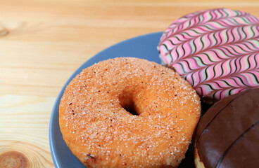 Closeup Sugar Cinnamon Doughnut on Assorted Doughnuts Plate
