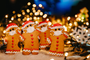 New Year and Christmas celebration in a coronavirus pandemic, conceptual background with unfocused lights and ginger man in face mask, copy space