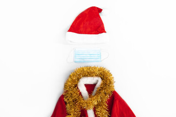 Christmas hat and santa claus costume with face mask on white background, christmas and new year concept, covid 19