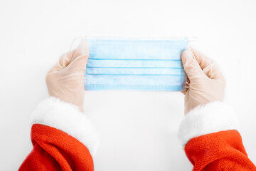 Covid-19 Santa Claus, Santa Claus hands holding a medical face mask, on a white background