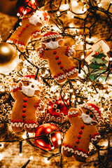 Naklejka premium Special New Year's background with elements of the Christmas cookies, festive lights, Christmas ornaments: gingerbread in the shape of Santa Claus with a protective medical