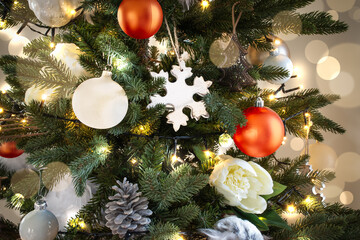 Illuminated Christmas tree with white and orange Christmas decorations and light flare.