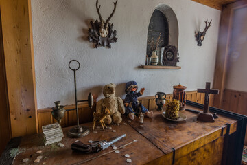 pistol and dolls on a cabinet in a room from a abandoned house