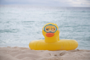 LIFEGUARD YELLOW INFLATABLE DUCK WITH DIVE MASK ON THE SHORES OF A VIRGIN TROPICAL BEACH IN THE CARIBBEAN