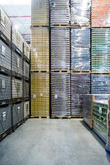 Tall stack of products on pallets in warehouse