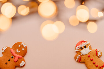Fototapeta na wymiar Gingerbread masked man cookies on the background with unfocused lights: New Year and Christmas celebration in a coronavirus pandemic