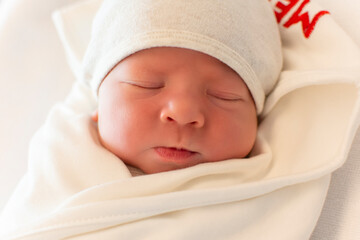 Portrait of cute and beautiful newborn baby in hospital after delivery. First days of life. Lifestyle