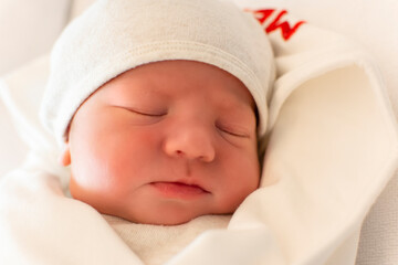 Portrait of cute and beautiful newborn baby in hospital after delivery. First days of life. Lifestyle