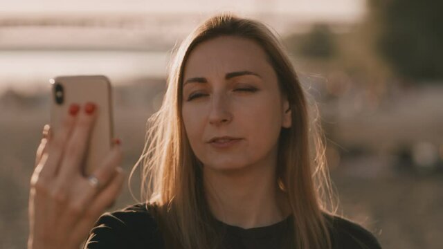 Young woman has a videocall. She winced as she sow something grose. She is angry and nervous. The conversation is unpleasant.