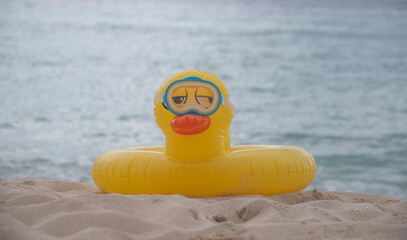 LIFEGUARD YELLOW INFLATABLE DUCK WITH DIVE MASK ON THE SHORES OF A VIRGIN TROPICAL BEACH IN THE CARIBBEAN