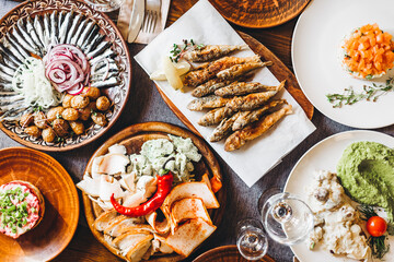 a large clay plate with a national Slavic delicacy - thinly sliced lard with spices on the table...