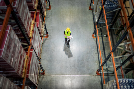 View from above of warehouse worker with laptop at work
