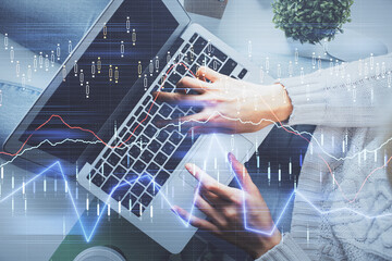 Double exposure of woman hands working on computer and forex chart hologram drawing. Top View. Financial analysis concept.