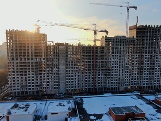 Aerial view construction of a modern office building. The work of building tower cranes against the background of the cityscape