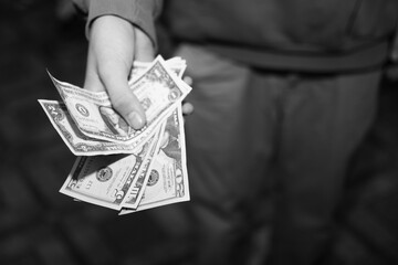 a young guy holds American dollars in his hands