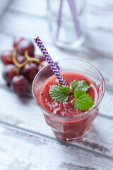 Fresh smoothie in a glass. Bright wooden background. Close up. 