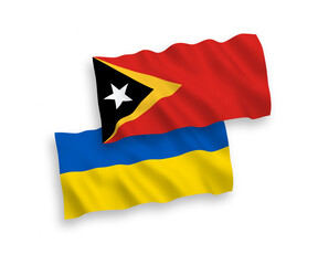 National vector fabric wave flags of East Timor and Ukraine isolated on white background. 1 to 2 proportion.