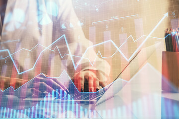 Double exposure of woman hands typing on computer and forex chart hologram drawing. Stock market...