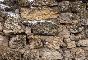 ancient masonry close up cracked with time and overgrown with moss