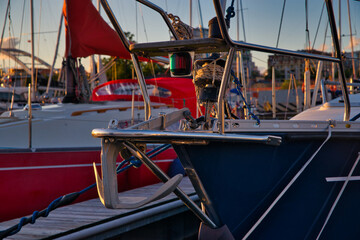 Moored boats in the port. Yachts and boats at sea against the backdrop of the setting sun. Sailboat travel concept.