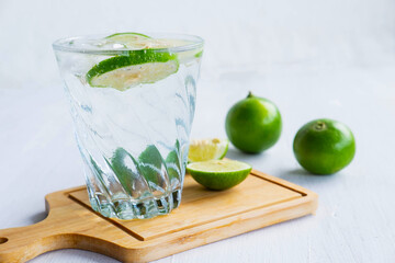 A glass of soda, lemon and lime on the table