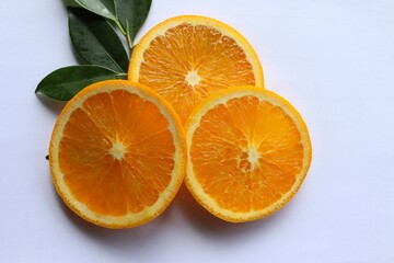 Orange fruit, fruits or vegetables, slices with green leaves isolated on white background closeup.