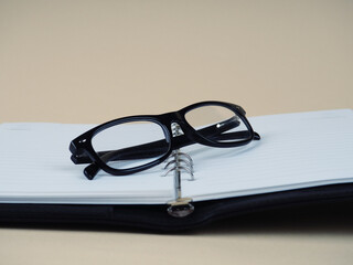 glasses on a black Notepad, stylish background. Copy space for your text.