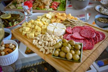 Cheese platter with other condiments on a wooden board on a table 