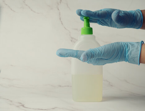 Hands In Medical Gloves Hold Antiseptic To Prevent A Pandemic. Desinfection Hand Sanitizer Applying Alcohol