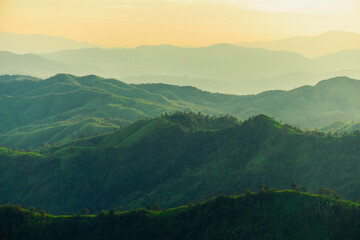 beautiful huge green mountain range shillouete in sunset time with fog - Powered by Adobe