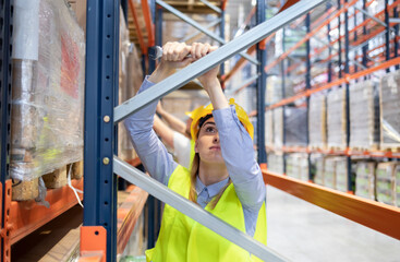 Fototapeta na wymiar Worker during rack arrangement erection work in warehouse
