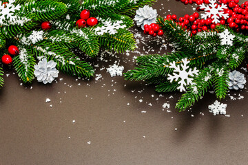 Christmas or New Year festive background with evergreen fir branches, pine cones and snowflakes