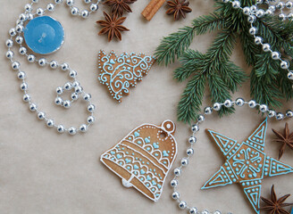 Blue gingerbread composition. Christmas, New year card with fur tree branch, gingerbread, cinnamon, anise on craft paper background. Place for text, top view