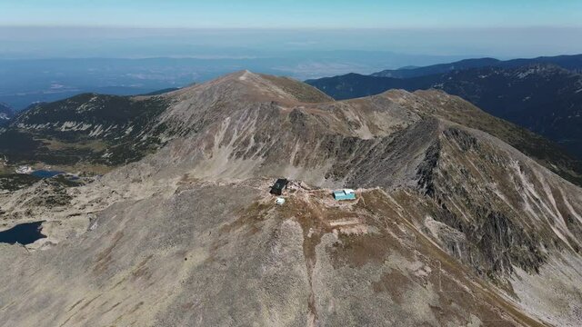 Musala Cape, Rila Mountains, Borovets, Bulgaria. Tourists hiking along dangerous mountain range. Beautiful mountain view from drone turn summer sunny day against blue sky background. Nature. Freedom